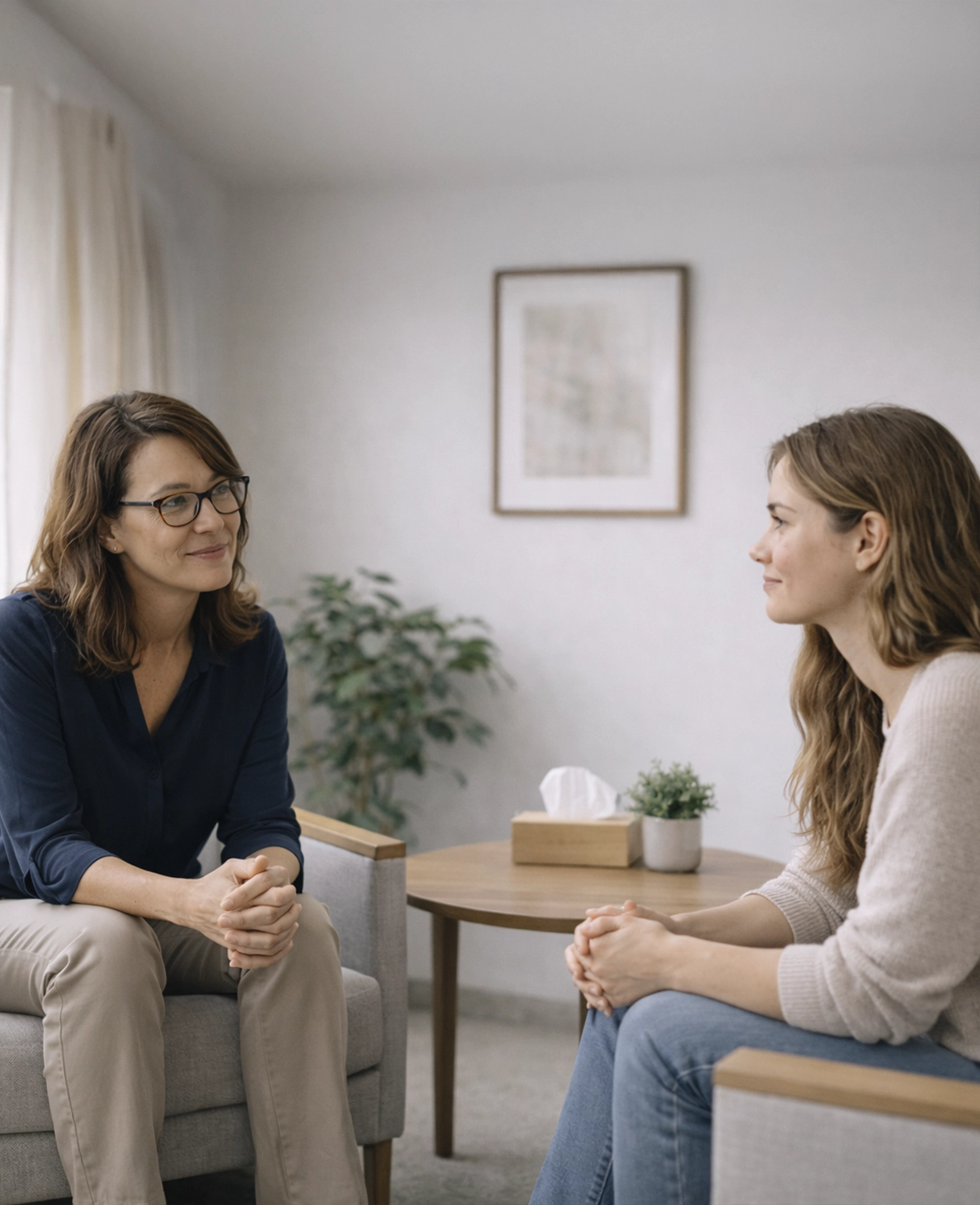Female client and therapist seated in a calm, neutral-toned office during a trauma-informed outpatient therapy session in Boise, Idaho.